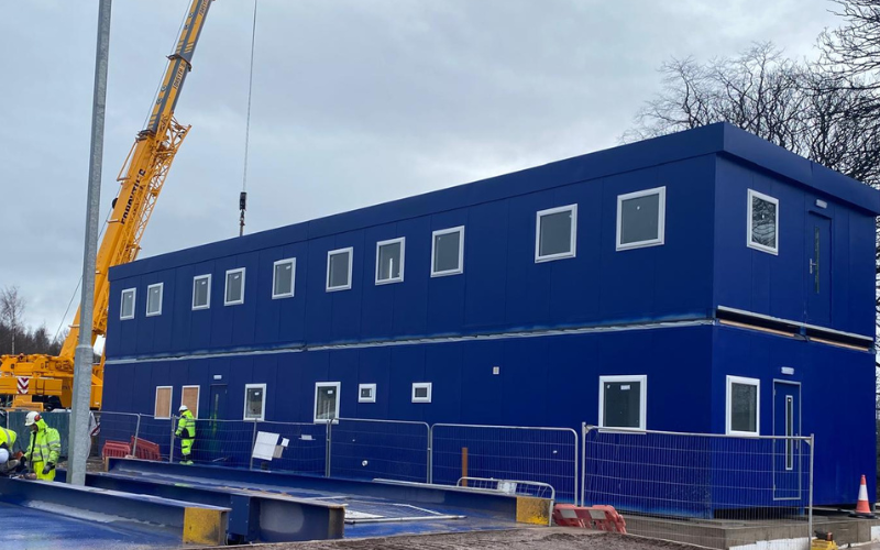 Two storey blue modular building being installed on site