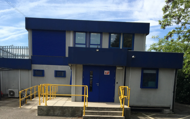 Two storey modular building exterior with blue trim and entrance ramp