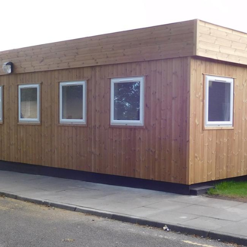 Timber clad portable building exterior with multiple windows