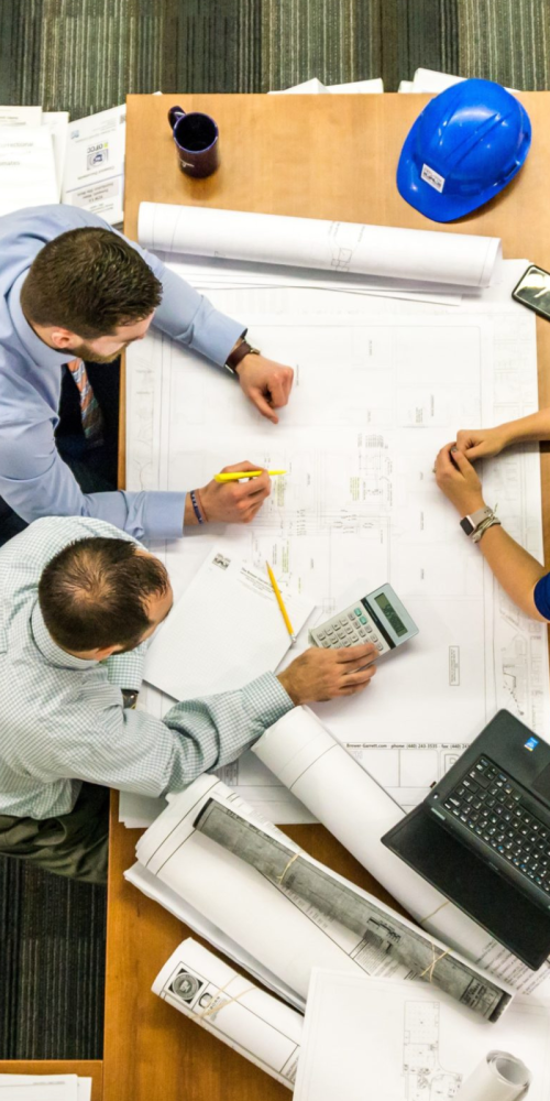 Team reviewing building plans and drawings around a table