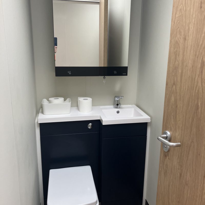 Modular building interior bathroom with vanity unit and toilet